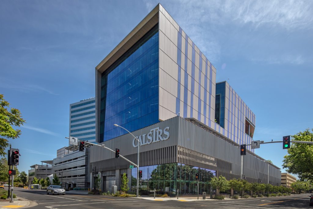 Main front entrance view of the CalSTRS, a multi-story office building with a large panel of glass