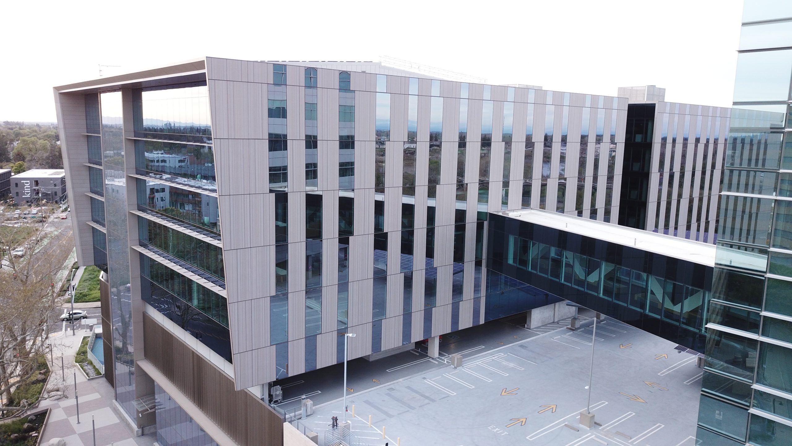 View of the CalSTRS Tower open air, mid level parking with sky way.