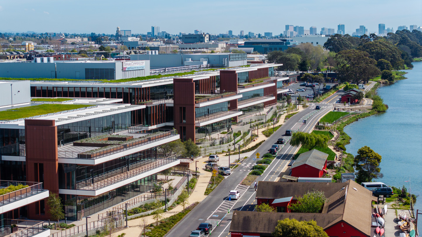 View from above showing the building next to the water line with a cityscape in background