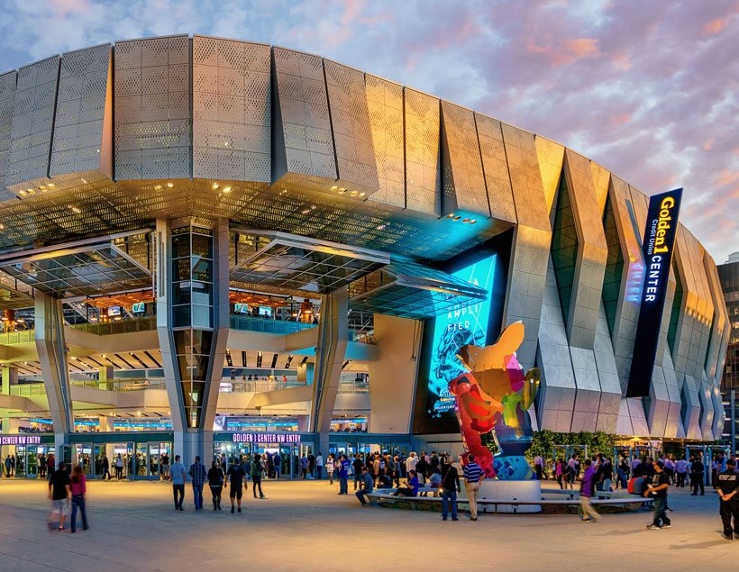 Golden 1 Center at dusk with crowds of people at entrance